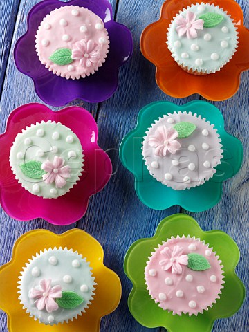 Flower iced cupcakes on a blue background