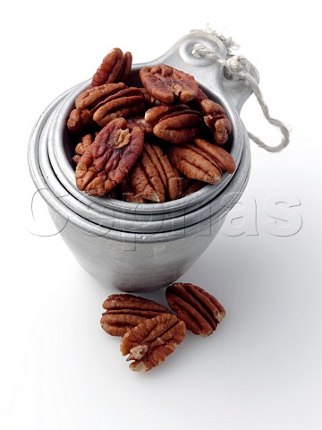 Pecan nuts in antique measuring cup stack