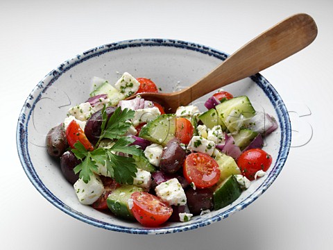 Bowl of Greek salad on a white background