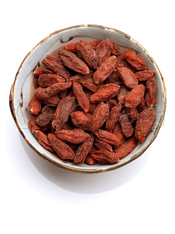 A bowl of goji berries on a white background