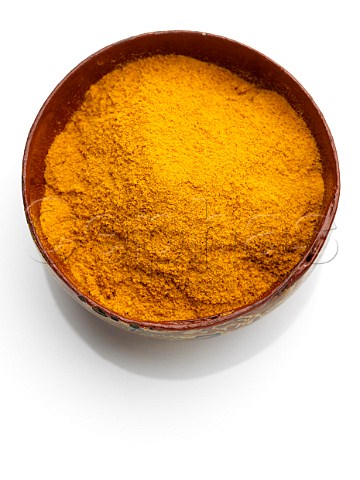A bowl of turmeric on a white background
