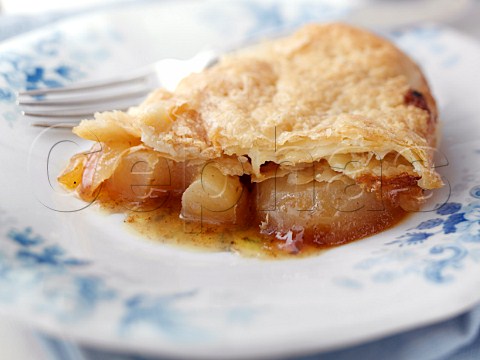 Individual portion of caramelized apple pie on an antique plate