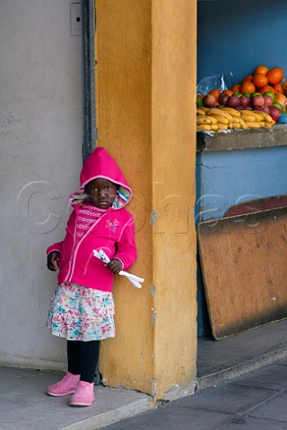 Young girl standing by small fruit shop Amanzimtoti KwaZuluNatal South Africa