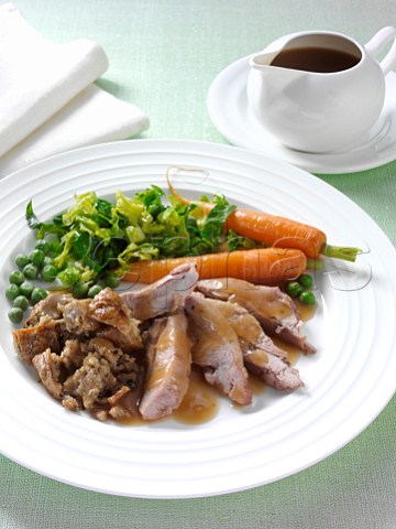 Roast turkey thigh with stuffing carrots cabbage peas and gravy