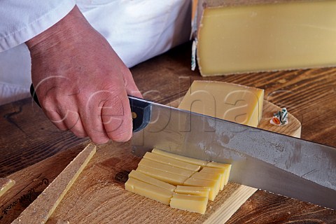 Slicing Comt cheese at Fromageries Marcel Petite Fort Saint Antoine near Malbuisson Doubs France