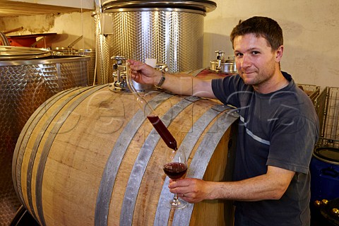 Patrice Bguet with barrel which he uses for whole berry fermentation Domaine HughesBguet Mesnay Jura France Arbois