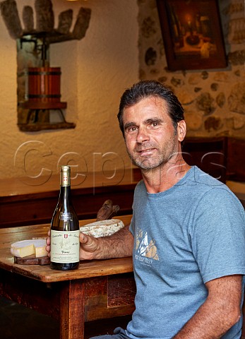 Bruno Lupin with local cheeses and bottle of his Cuve du Pp Roussette de Savoie in his familys auberge Domaine Lupin Frangy HauteSavoie France