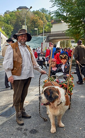 Man in traditional dress with a St Bernard dog preparing for the Retour des Alpages festival Annecy HauteSavoie France