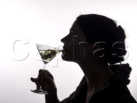 Silhouette of a woman sipping a martini