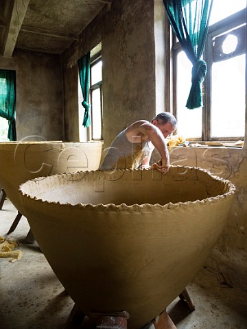 Zaliko Bozhadze master potter building a clay qvevri fermentation vessel in his studio Maqatubani Imereti region Georgia