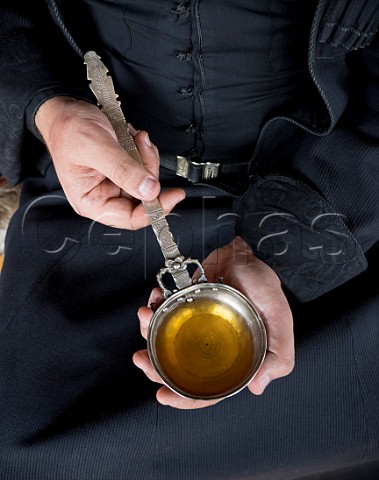 The tamada toastmaster holding an azarpesha silver drinking vessel containing an orange wine which has been macerated in a qvevri He is wearing the traditional Georgian coat the chokha  Pheasants Tears winery Sighnaghi Kakheti Georgia