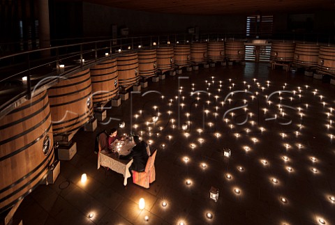Couple having a romantic dinner in the fermentation room of Clos Apalta winery Colchagua Valley Chile