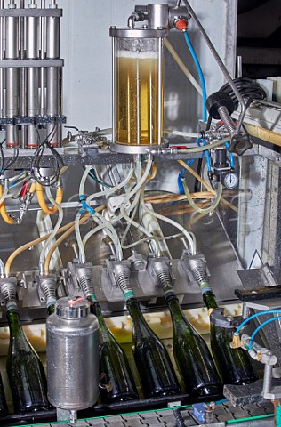 Machine adding the dosage to bottles of sparkling wine after disgorging Wiston Estate winery Washington Sussex England