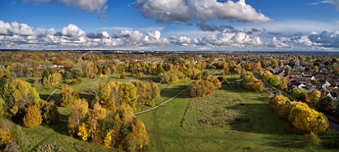 Autumnal view of Hurst Park by the River Thames in East Molesey Surrey  St Pauls Church is on right and on left of horizon are the City of London and Canary Wharf 27km away