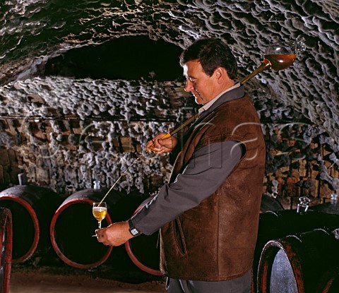 Filling a tasting glass with wine  taken from barrel with a pipette  in the ancient mouldcovered cellars of Tokaj Kereskedhz Tolcsva Hungary Tokaji