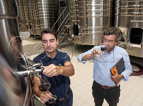 Edouardo Massi oenologist and Fabien Vincent tasting wine from tank in cellar of Chteau LamotheVincent Montignac Gironde France  Bordeaux