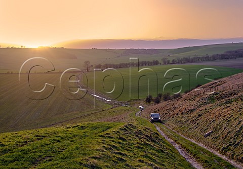 Land Rovers climbing on a byway to Sugar Hill on the Marlborough Downs at sunset Wiltshire England